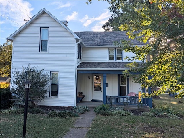 view of property featuring a front lawn and a porch