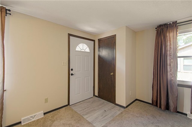 foyer featuring light colored carpet