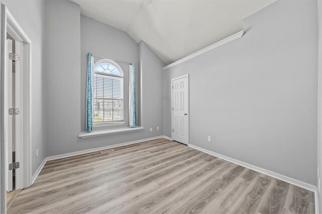 unfurnished room with light hardwood / wood-style flooring and vaulted ceiling