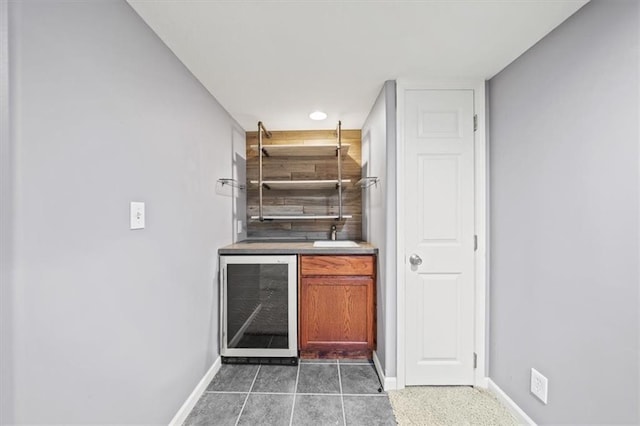 bar featuring wine cooler and dark tile patterned floors