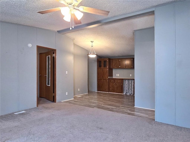 unfurnished living room featuring light wood-type flooring, a textured ceiling, ceiling fan, and lofted ceiling