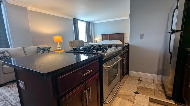 kitchen featuring ornamental molding, dark stone counters, a center island, and stainless steel appliances