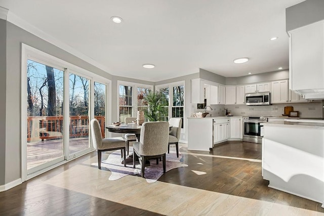 dining area with dark wood finished floors, recessed lighting, baseboards, and ornamental molding