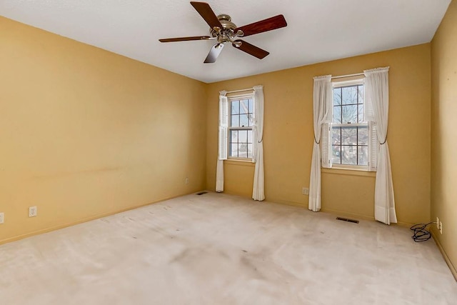 unfurnished room with visible vents, carpet floors, and ceiling fan