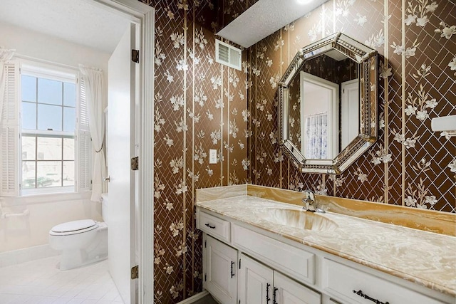 bathroom with tile patterned flooring, toilet, wallpapered walls, and vanity