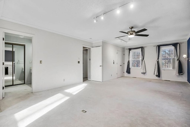 unfurnished bedroom featuring track lighting and ornamental molding