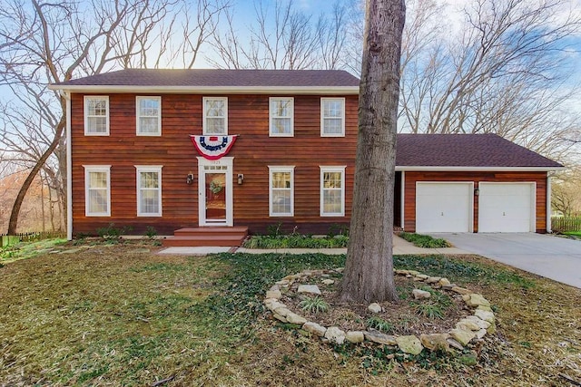 colonial inspired home with concrete driveway and an attached garage