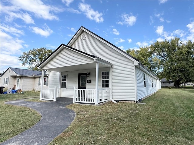 bungalow-style home featuring a front yard and covered porch