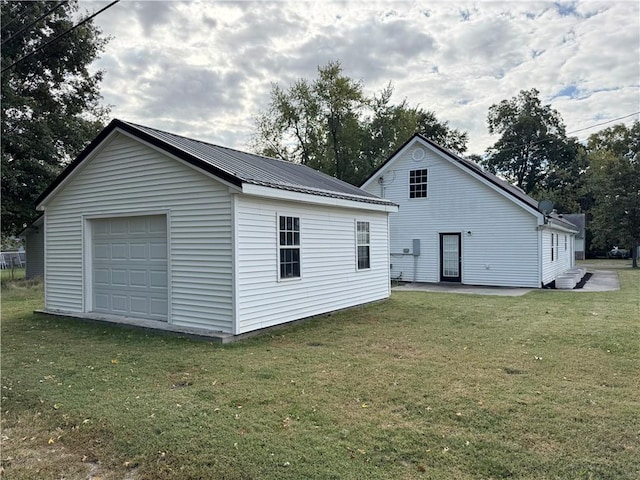 rear view of property with a yard and an outbuilding