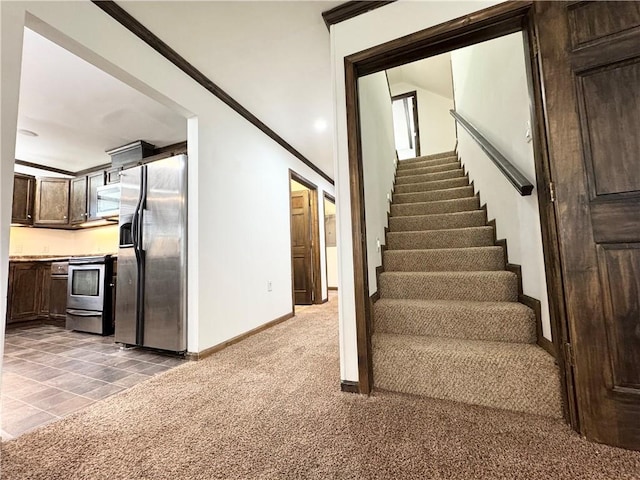 staircase featuring crown molding and carpet flooring