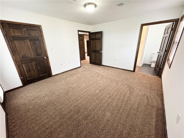 unfurnished bedroom with connected bathroom and carpet