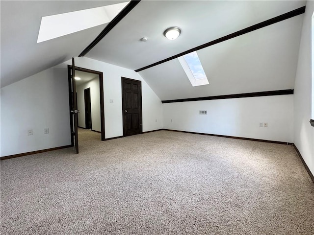 additional living space featuring carpet floors and lofted ceiling with skylight