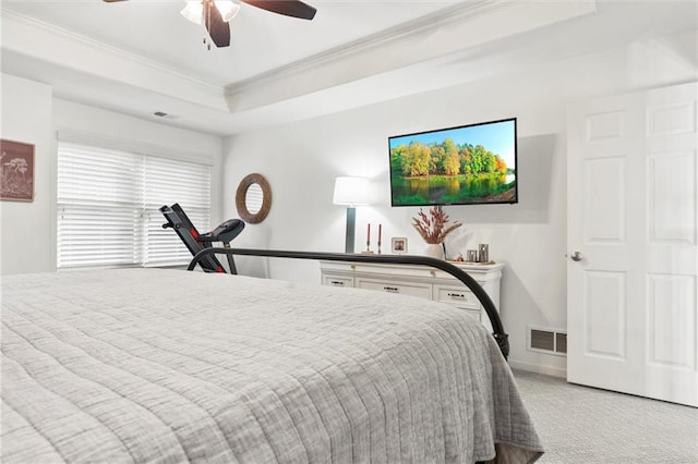 carpeted bedroom featuring crown molding, ceiling fan, and a tray ceiling