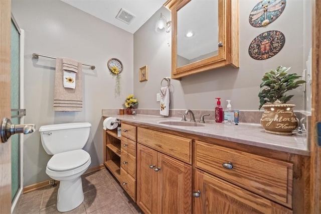 bathroom featuring vanity, a shower with shower door, toilet, and tile patterned floors