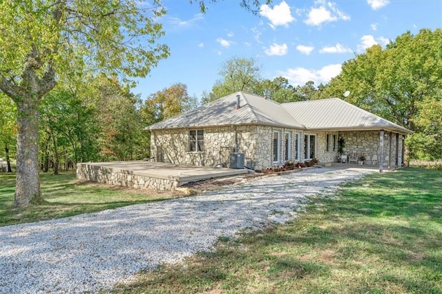 exterior space featuring central AC unit, a front yard, and a patio area