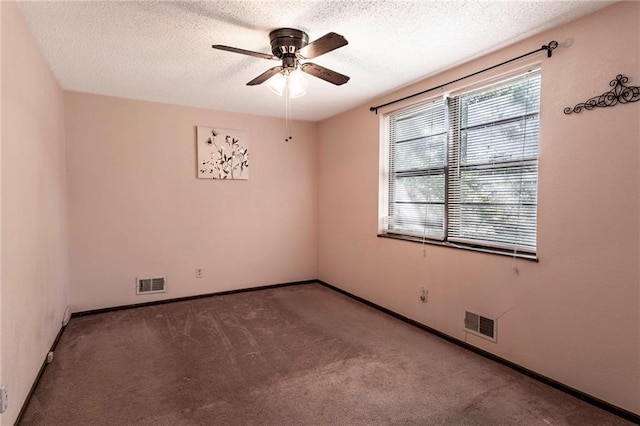 unfurnished room featuring ceiling fan, carpet floors, and a textured ceiling