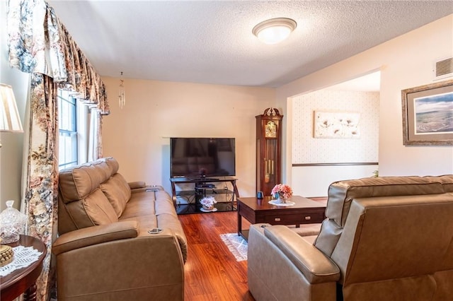 living room featuring wood-type flooring and a textured ceiling