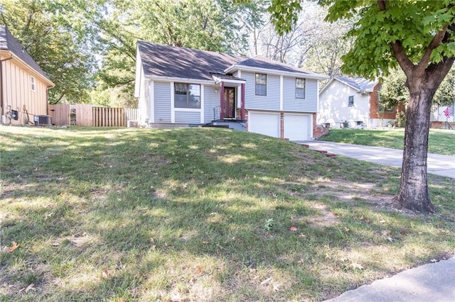 split level home with a garage, a front lawn, and central AC unit