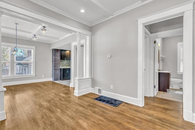 unfurnished living room with a brick fireplace, crown molding, coffered ceiling, hardwood / wood-style flooring, and ornate columns