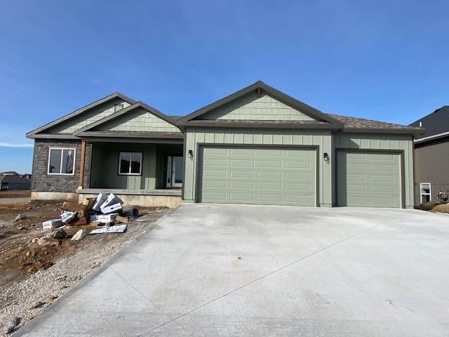 view of front facade featuring an attached garage, board and batten siding, and concrete driveway