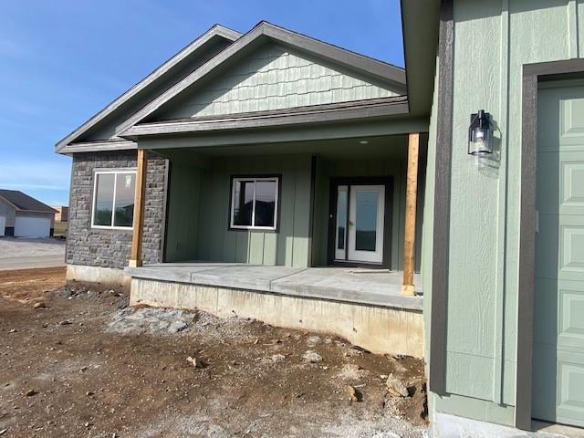 view of home's exterior with stone siding and a porch