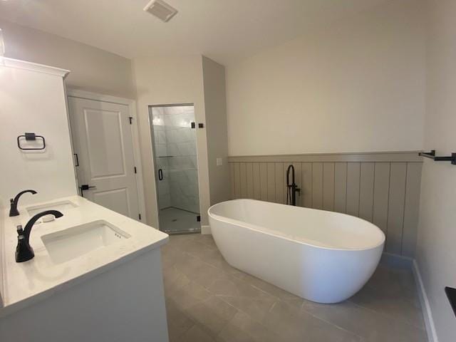 full bath featuring a freestanding tub, a shower stall, visible vents, and a sink