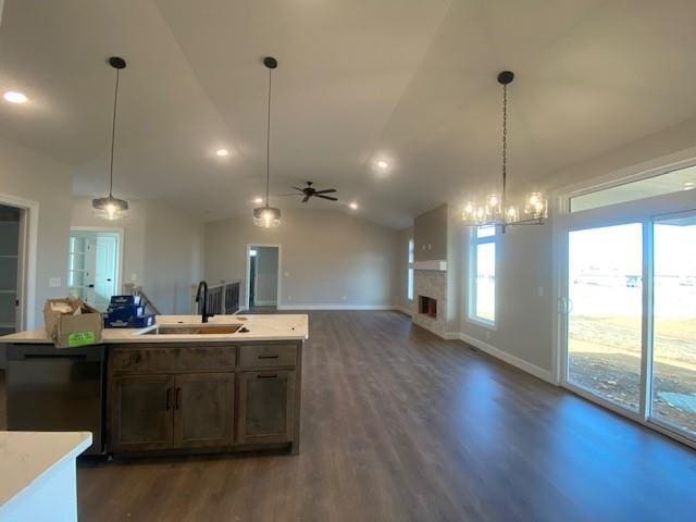 kitchen featuring dark wood finished floors, lofted ceiling, light countertops, open floor plan, and a sink