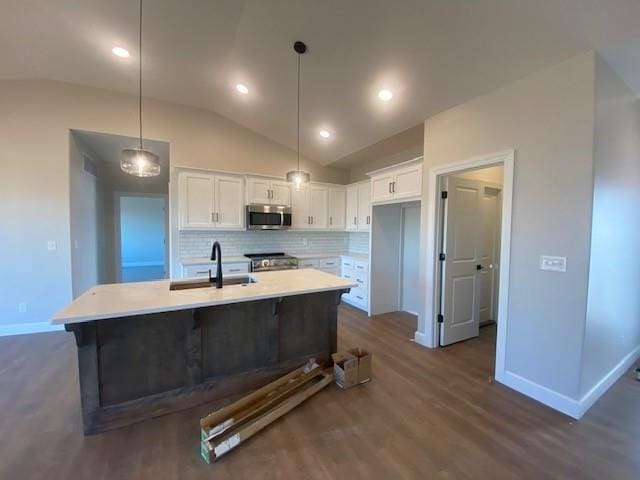 kitchen featuring tasteful backsplash, appliances with stainless steel finishes, light countertops, white cabinetry, and a sink