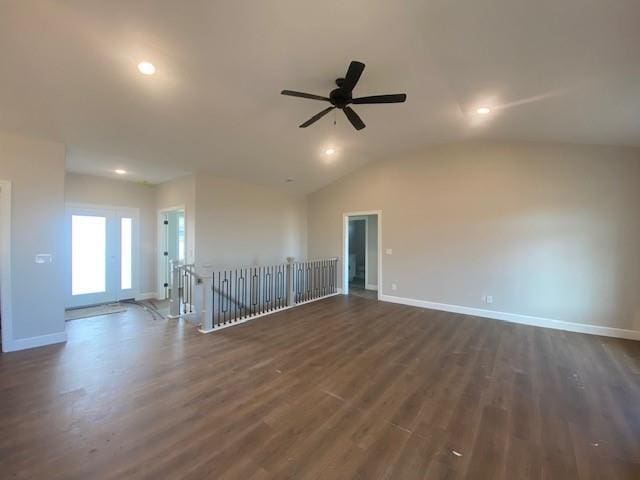 empty room with ceiling fan, baseboards, vaulted ceiling, and dark wood-type flooring