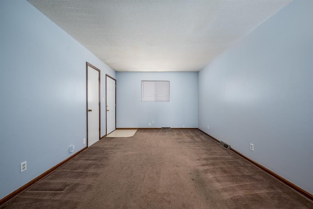 empty room featuring a textured ceiling and carpet floors