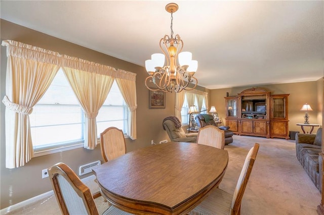 dining room featuring light colored carpet and an inviting chandelier