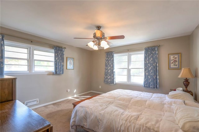 carpeted bedroom with multiple windows and ceiling fan