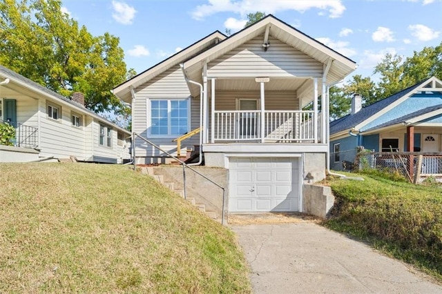 3146 Lafayette Ave, Kansas City, KS 66104 - view of front facade featuring aphalt driveway, a porch, an attached garage, and a front yard