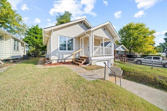 bungalow-style house featuring a porch, a front lawn, and central AC unit