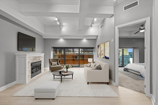 living room with a fireplace, ceiling fan, beam ceiling, and coffered ceiling