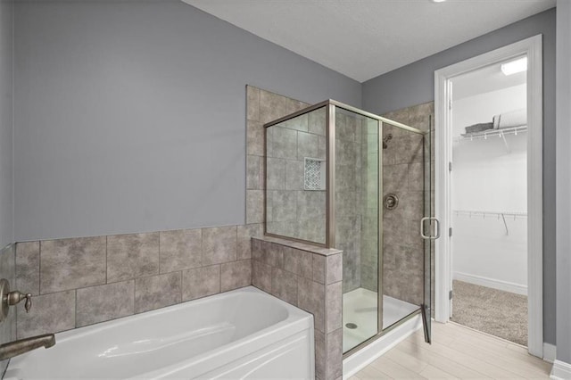 bathroom featuring independent shower and bath and wood-type flooring