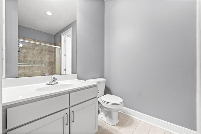 bathroom with toilet, an enclosed shower, and vanity