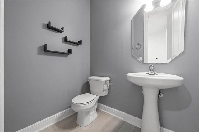 bathroom featuring hardwood / wood-style flooring and toilet