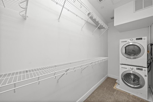 laundry room featuring carpet flooring and stacked washer and dryer