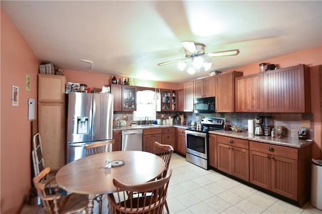 kitchen featuring appliances with stainless steel finishes, ceiling fan, sink, and backsplash