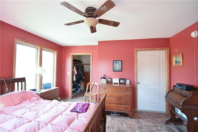 bedroom with a walk in closet, a closet, and ceiling fan