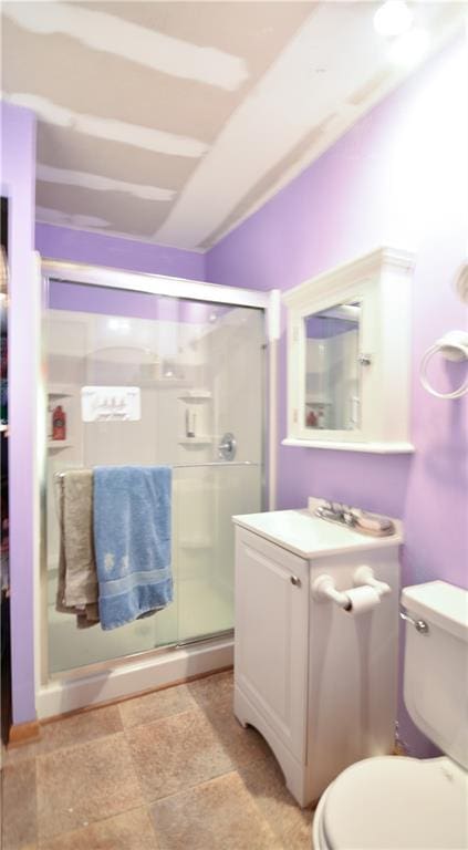 bathroom with toilet, a shower with shower door, and vanity