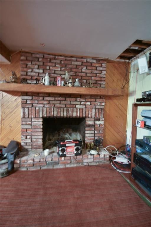 details with wooden walls, a brick fireplace, and carpet