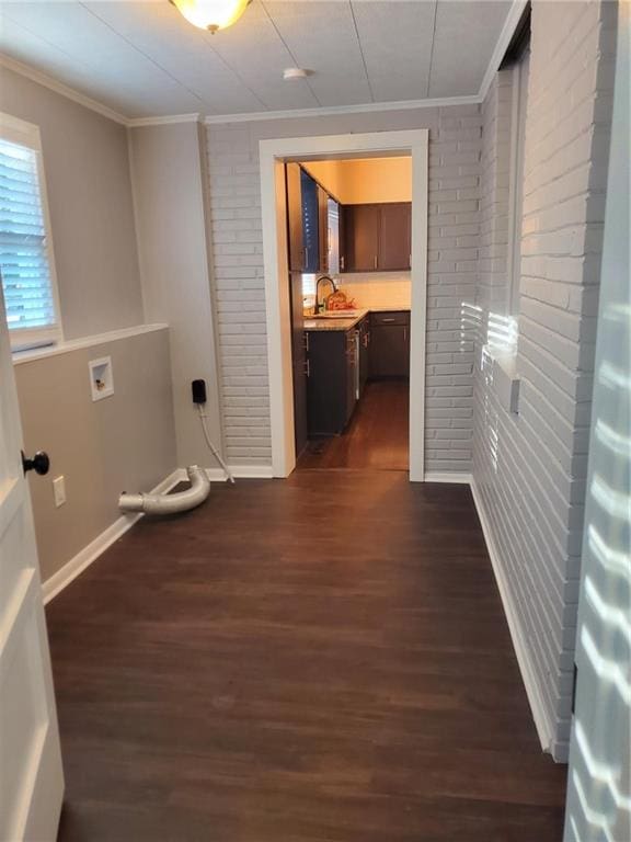 corridor featuring crown molding, sink, brick wall, and dark hardwood / wood-style flooring