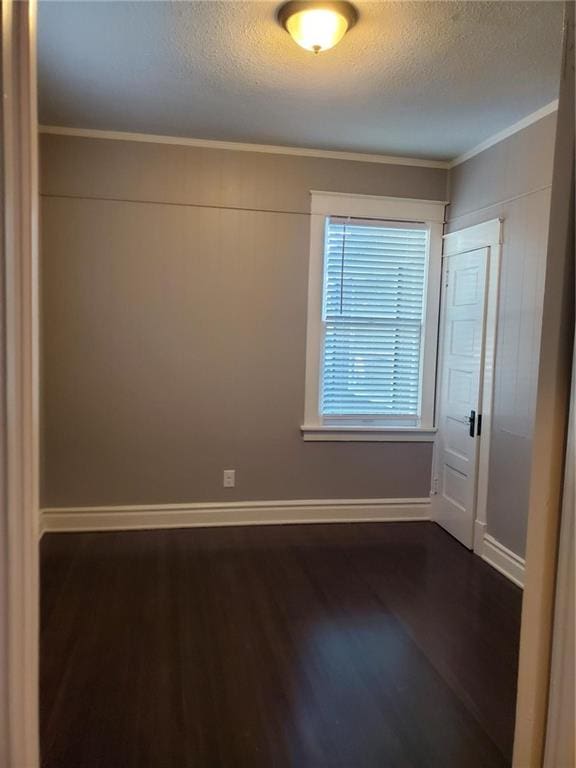 unfurnished room featuring crown molding, a textured ceiling, and dark hardwood / wood-style flooring