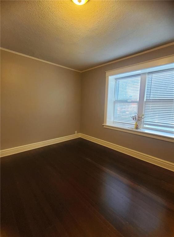 spare room featuring a textured ceiling, crown molding, and wood-type flooring