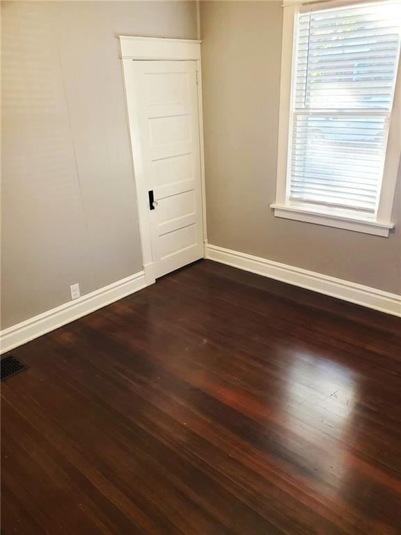 spare room with dark wood-type flooring