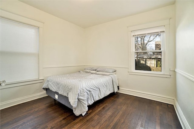 bedroom with dark hardwood / wood-style floors