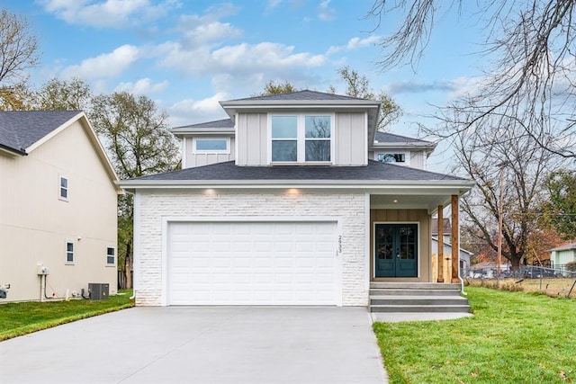 view of front of house with a front yard, central AC, and a garage