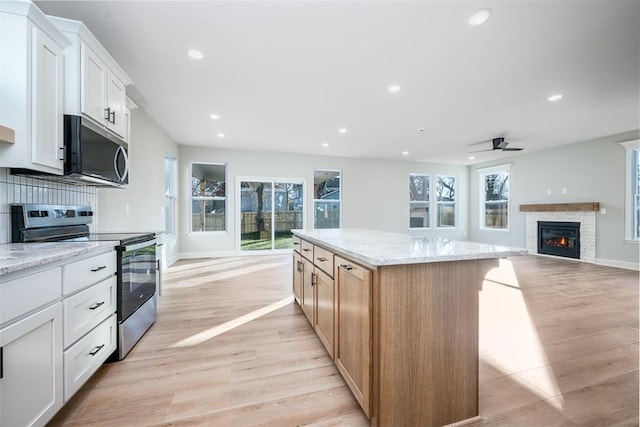 kitchen with white cabinets, stainless steel appliances, and a kitchen island